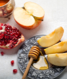 Image of apples and honey and pomegranates from our Celebratory Rosh Hashanah Menu