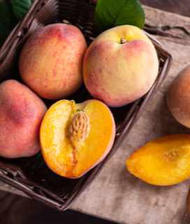 A photo of ripe summertime peaches in a basket