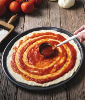 Photo of someone spreading San Merican Pizza Sauce on pizza dough