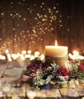 Photo of a candle on a wooden table for Winter Holiday Hours 2022 