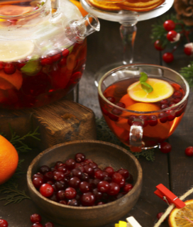 A pitcher of Amy's Christmas Punch with cranberreis and orange slices 