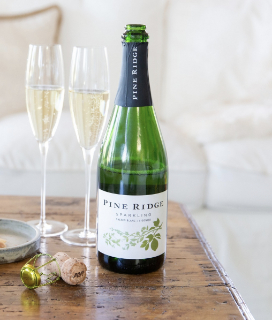 Pine Ridge Vineyards Sparkling Wine Chenin Blanc + Viognier on a table with two glasses