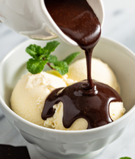 Phoot of Frans Dark Chocolate Sauce being poured over a bowl of vanilla ice cream