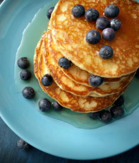 Photo of a stack of blueberry pancakes on a blue plate for Stonewall Kitchen Farmhouse Pancake Mix
