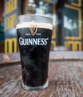 A glass of Guinness Stout on an outdoor wooden table