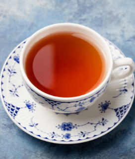 A cup of Stash Double Bergamot Earl Grey Tea on a blue table