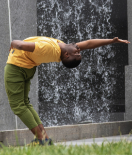 Photo of a dancer in front of a waterfall for YGB ChoreoFest