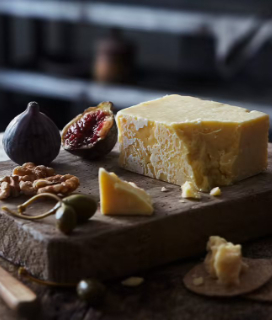 photo of Ivy's Reserve Vintage Cheddar on a board with figs and walnuts